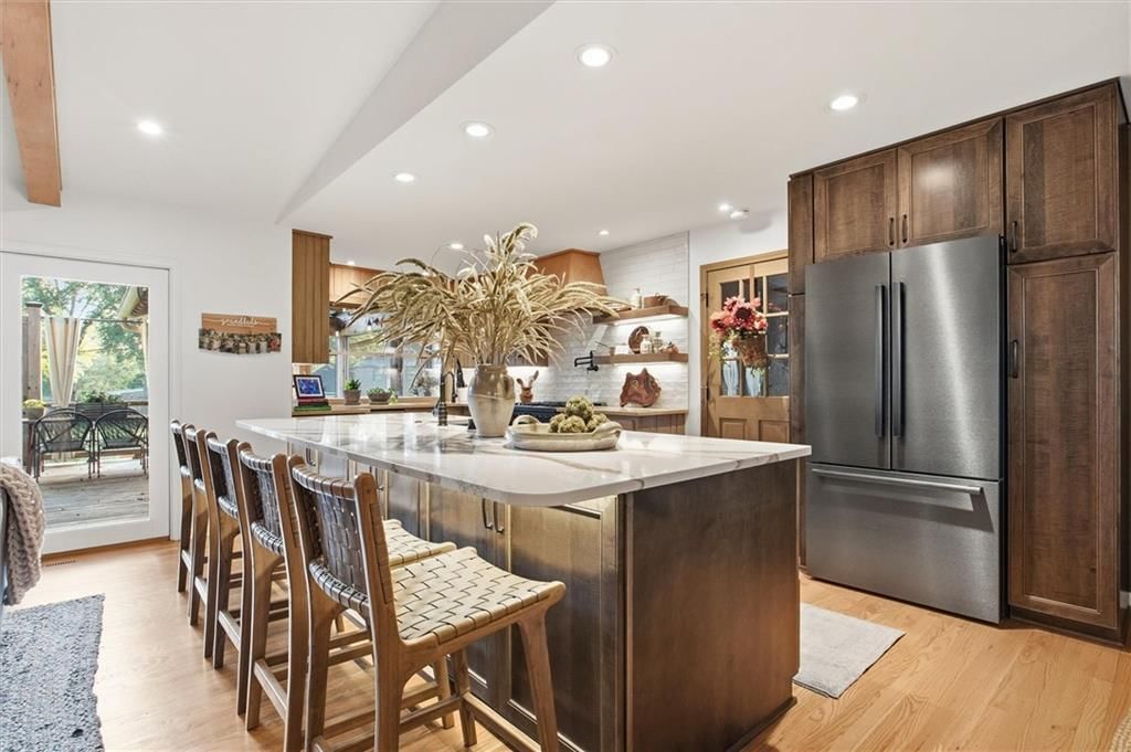 Kitchen island, stainless steel appliances and white countertops at 9815 Howe Drive, Overland Park, KS 66206