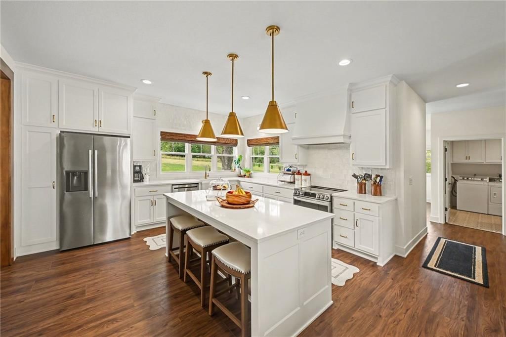 Open floor plan, kitchen island and white kitchen at 19920 NE F Highway, Smithville, MO 64089