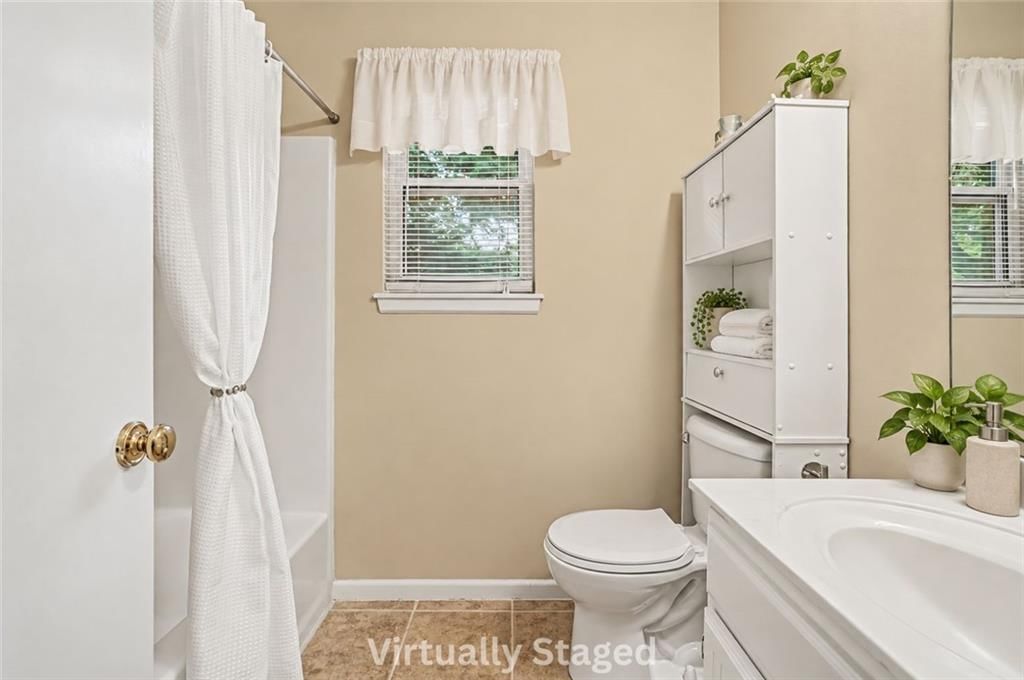 White vanity and tub and shower combo at 17405 MONTGALL Drive, Belton, MO 64012