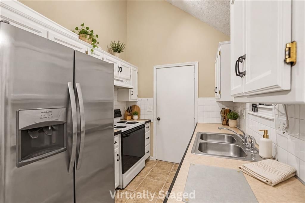 White kitchen, quartz counters and double oven at 17405 MONTGALL Drive, Belton, MO 64012