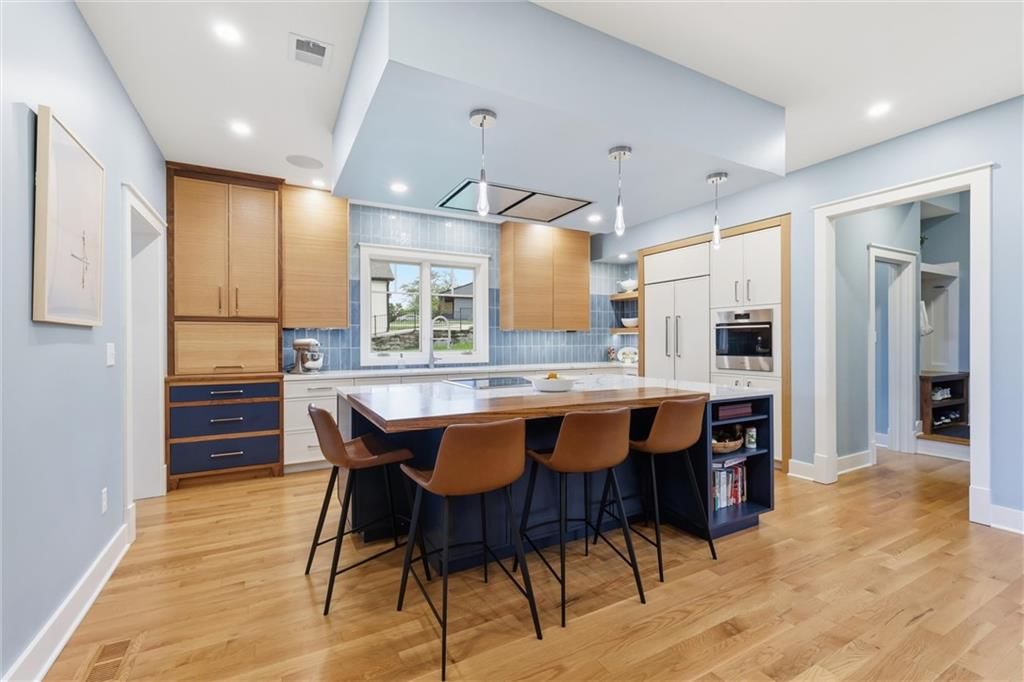 Kitchen island, quartz counters and two-tone kitchen cabinets at 43 L Street, Lake Lotawana, MO 64086