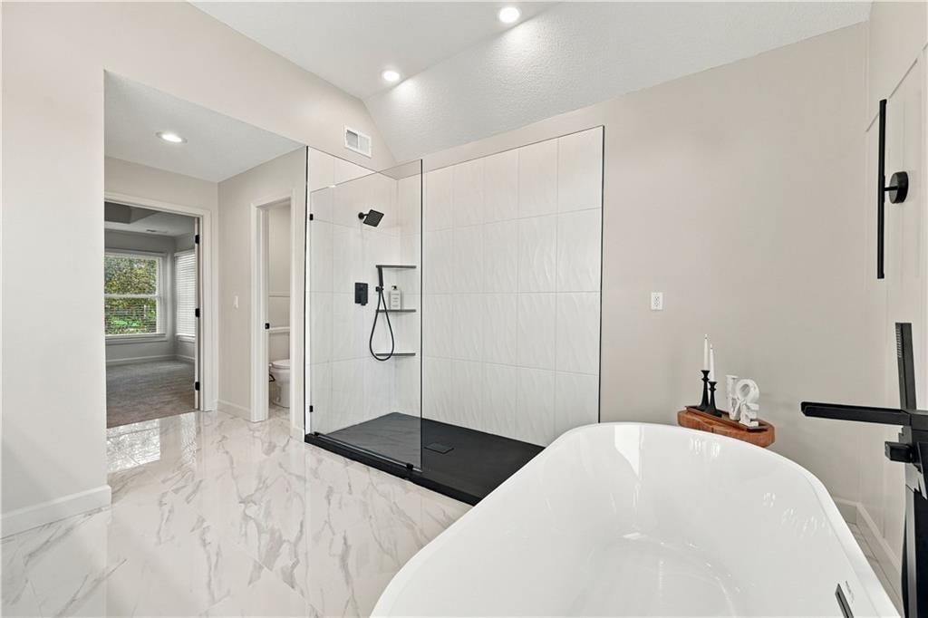 Walk-in shower, private toilet room and tiled shower at 8517 W 145th Terrace, Overland Park, KS 66223