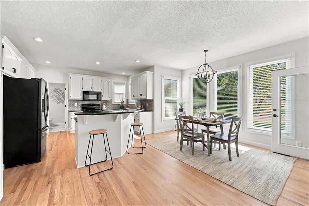 Open floor plan, kitchen island and white kitchen at 8517 W 145th Terrace, Overland Park, KS 66223