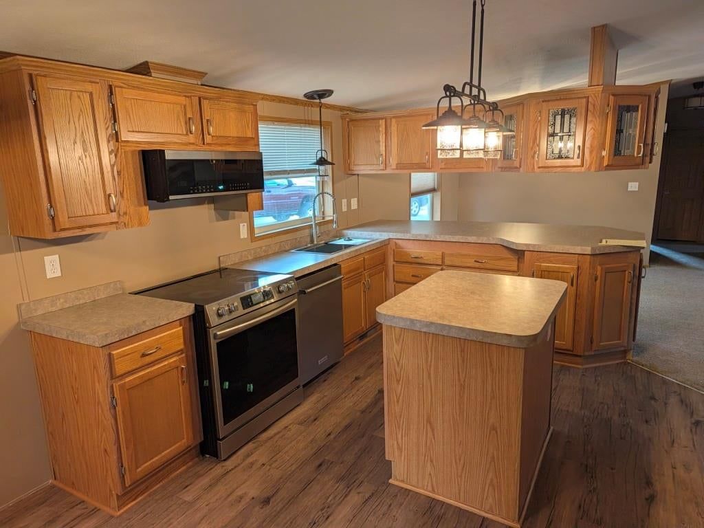 Kitchen island, stainless steel appliances and electric range at 846 NE White Oaks Lane, Oak Grove, MO 64075