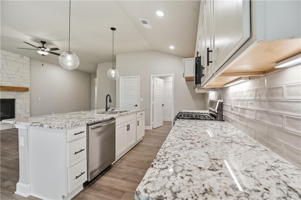 White kitchen, statement lighting and gas range at 18450 W 195th Street, Spring Hill, KS 66083