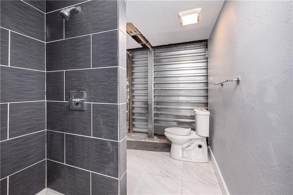 Walk-in shower, private toilet room and tiled shower at 102 W Kansas Avenue, Lansing, KS 66048