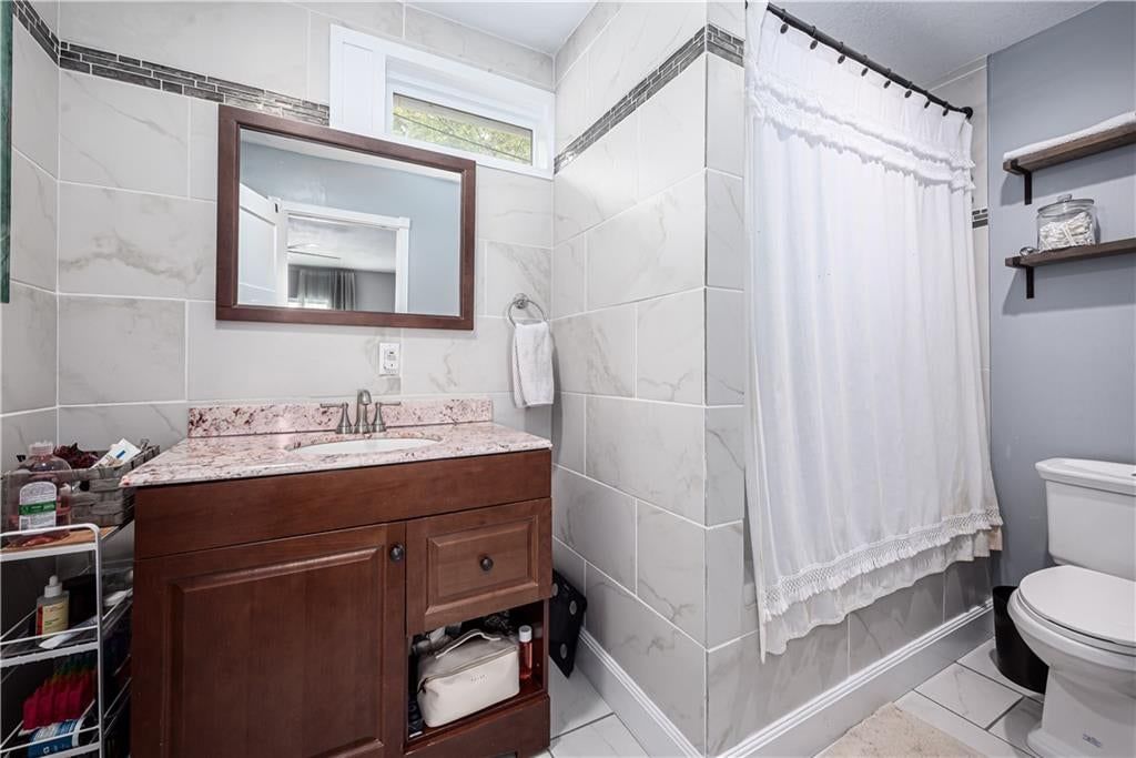 Tile floors, wood vanity and renovated bathrooms at 102 W Kansas Avenue, Lansing, KS 66048