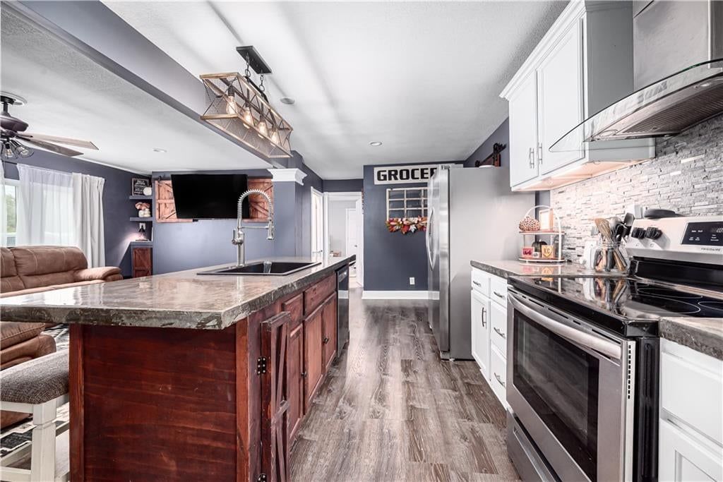 Kitchen island, white kitchen cabinets and quartz counters at 102 W Kansas Avenue, Lansing, KS 66048