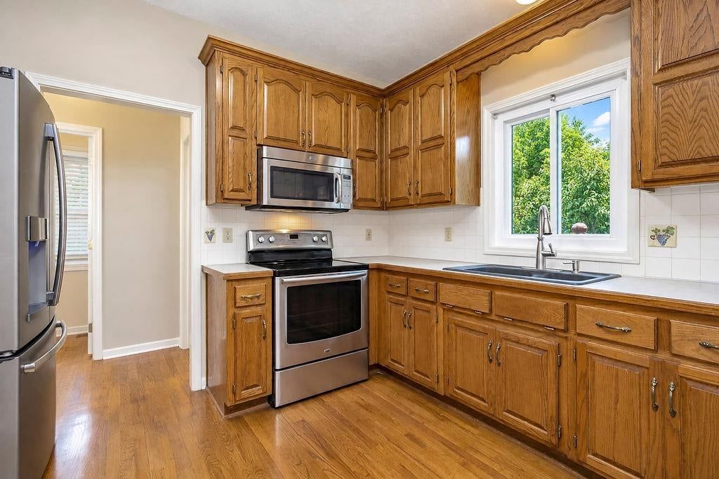 Stainless steel appliances, wood kitchen cabinets and electric range at 9921 N Highland Place, Kansas City, MO 64155