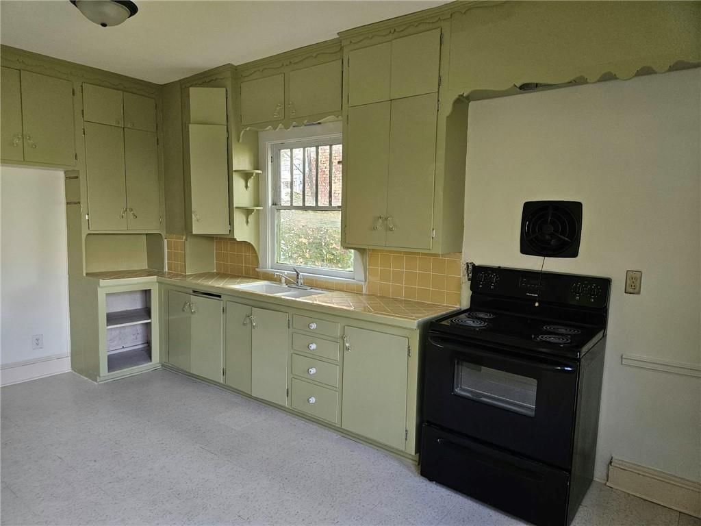 Green kitchen cabinets, kitchen backsplash and tile backsplash type at 1733 S Crescent Avenue, Independence, MO 64052