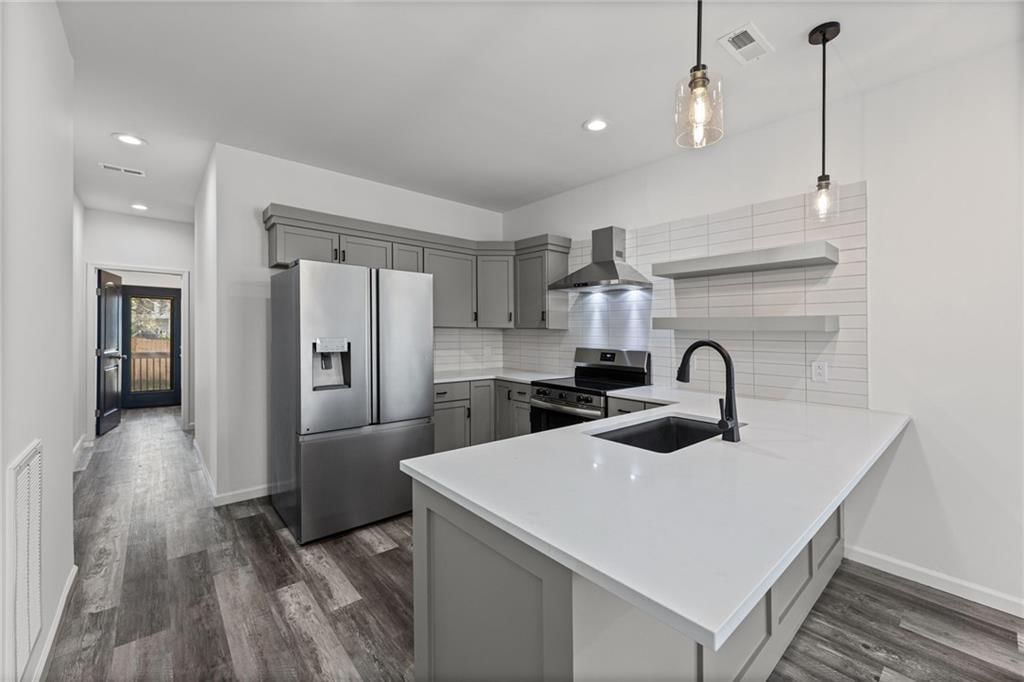 Kitchen island, quartz counters and statement lighting at 1111 Kimball Avenue, Kansas City, KS 66104