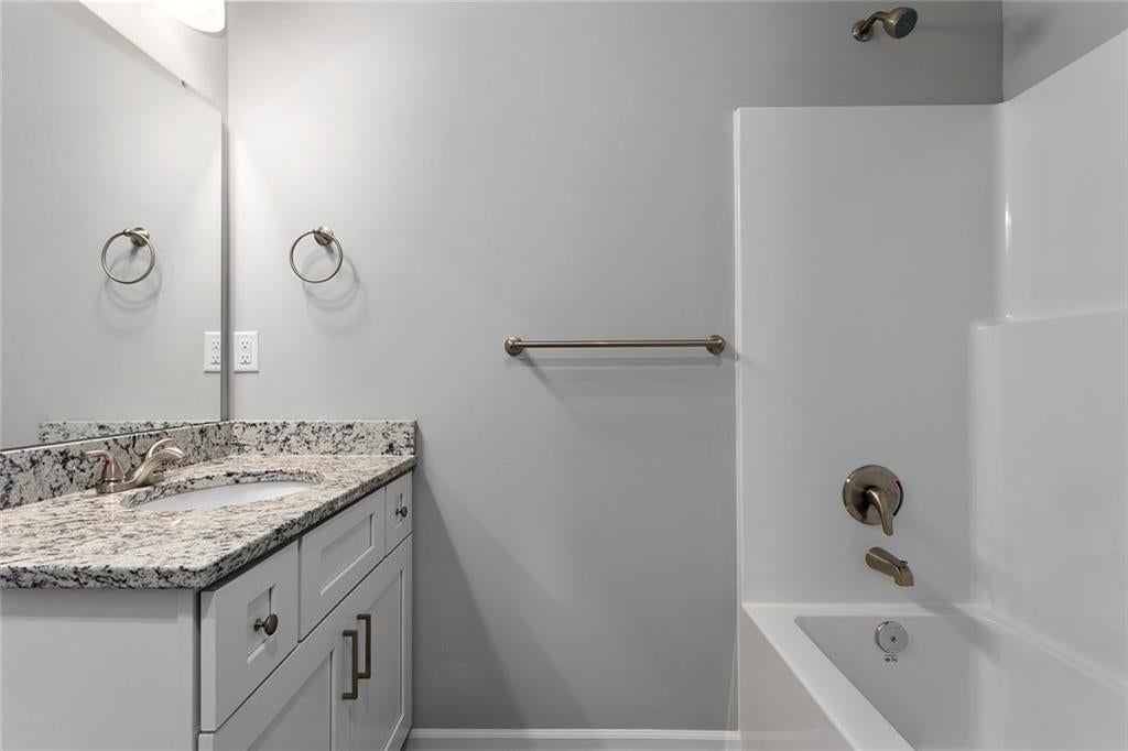 Tiled shower and frameless glass shower at 524 Lemon Mint Drive, Raymore, MO 64083