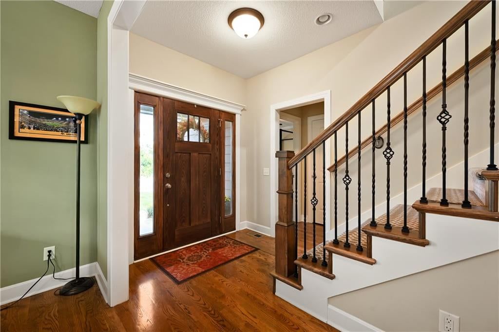 Hardwood floors, staircase and iron stair railing at 3317 SW Longview Road, Lee's Summit, MO 64081