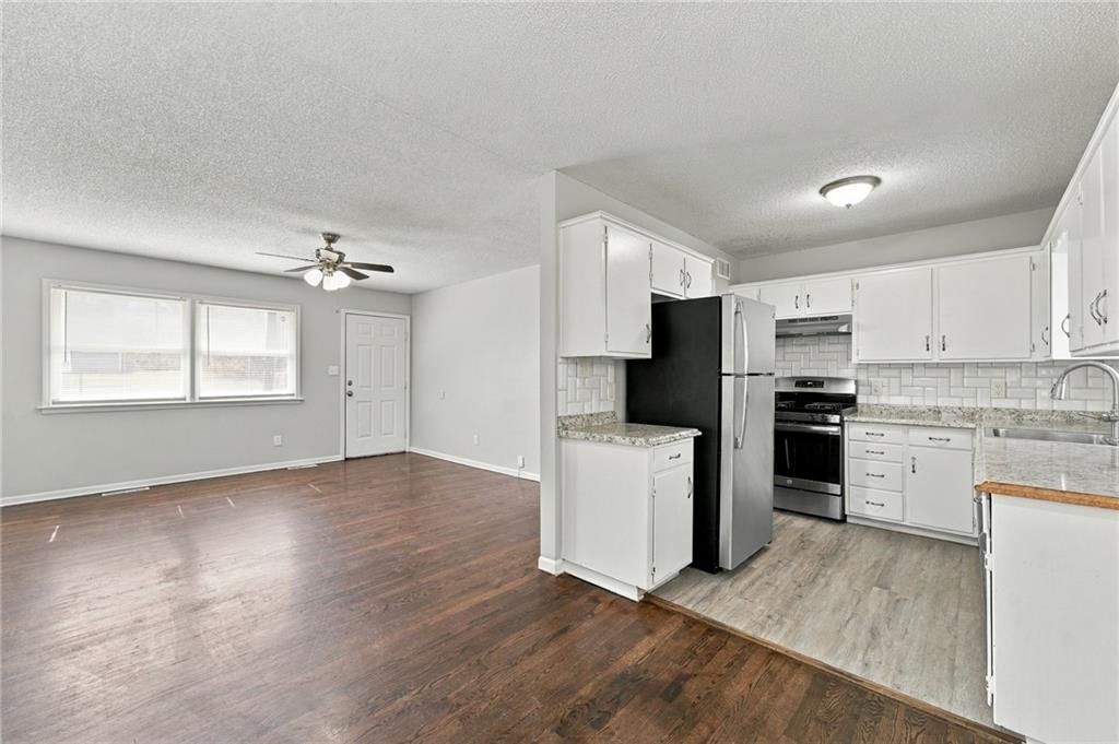 White kitchen, granite counters and gas range at 11134 E 9th Street S, Independence, MO 64054