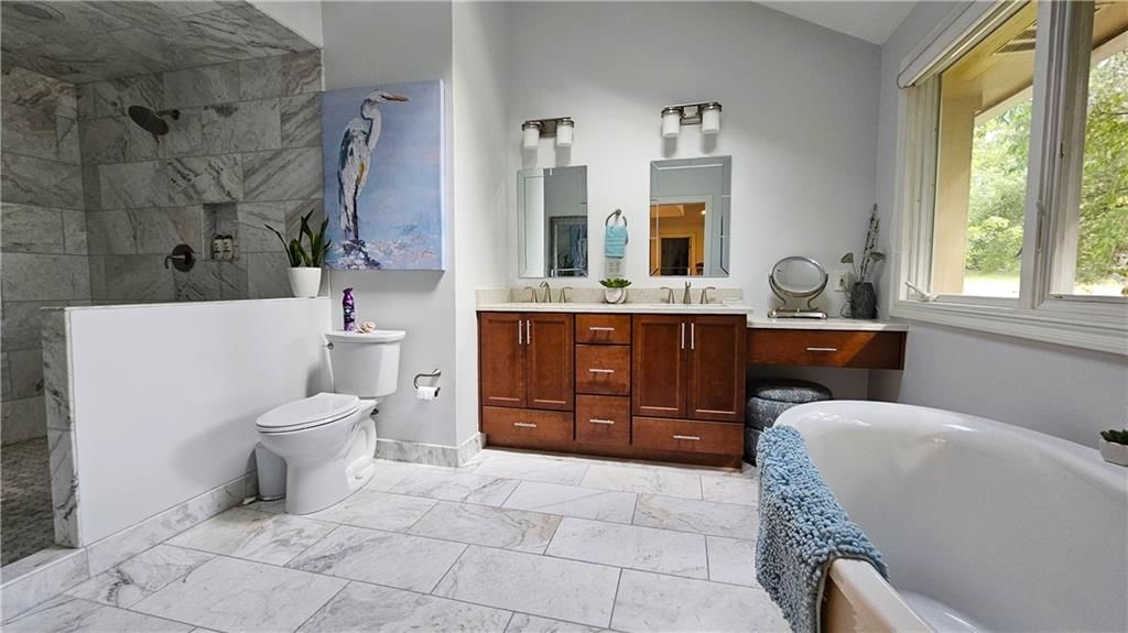 Tile floors, freestanding tub and double vanity at 12580 S Red Bird Lane, Olathe, KS 66061