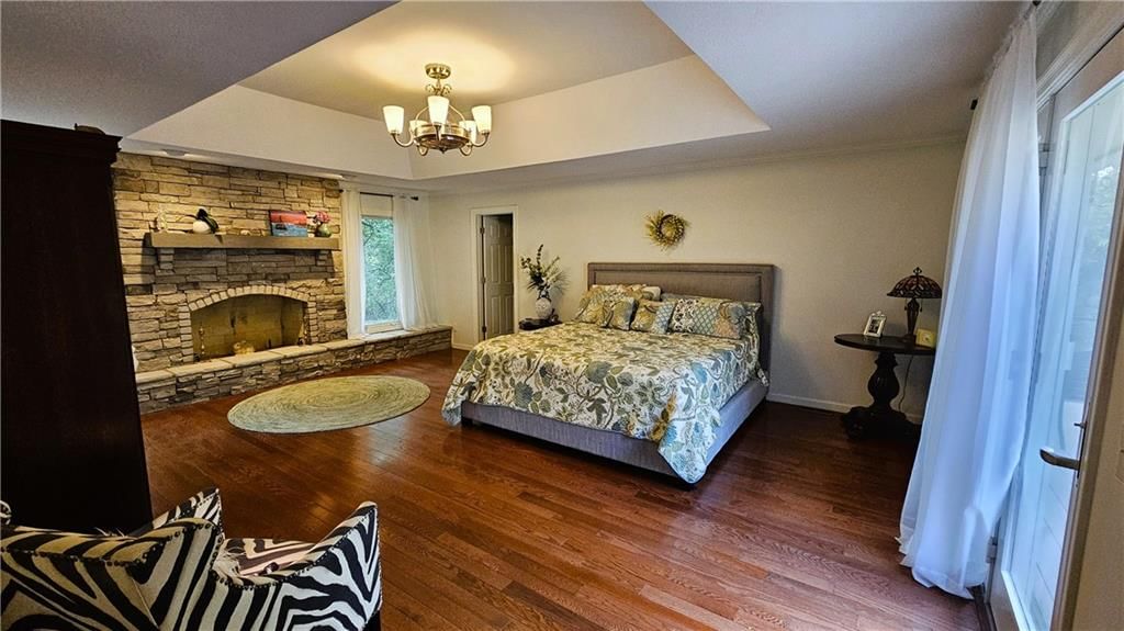 Main-floor primary bedroom, tray ceiling and bedroom sitting area at 12580 S Red Bird Lane, Olathe, KS 66061