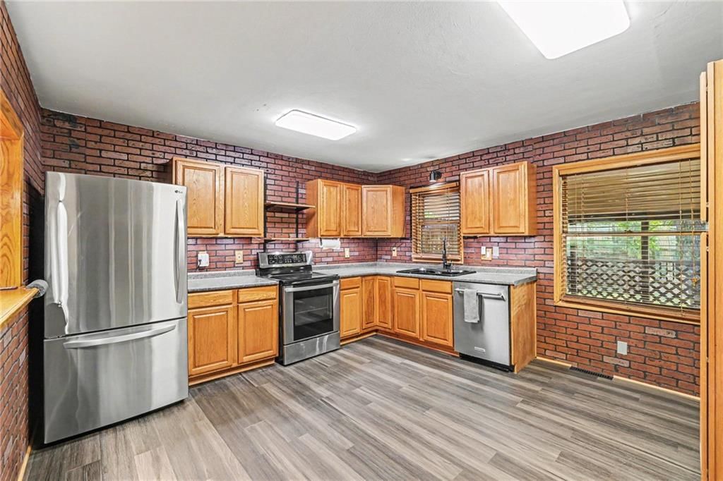 Exposed brick wall, stainless steel appliances and wood kitchen cabinets at 1305 S 40th Street, Kansas City, KS 66106