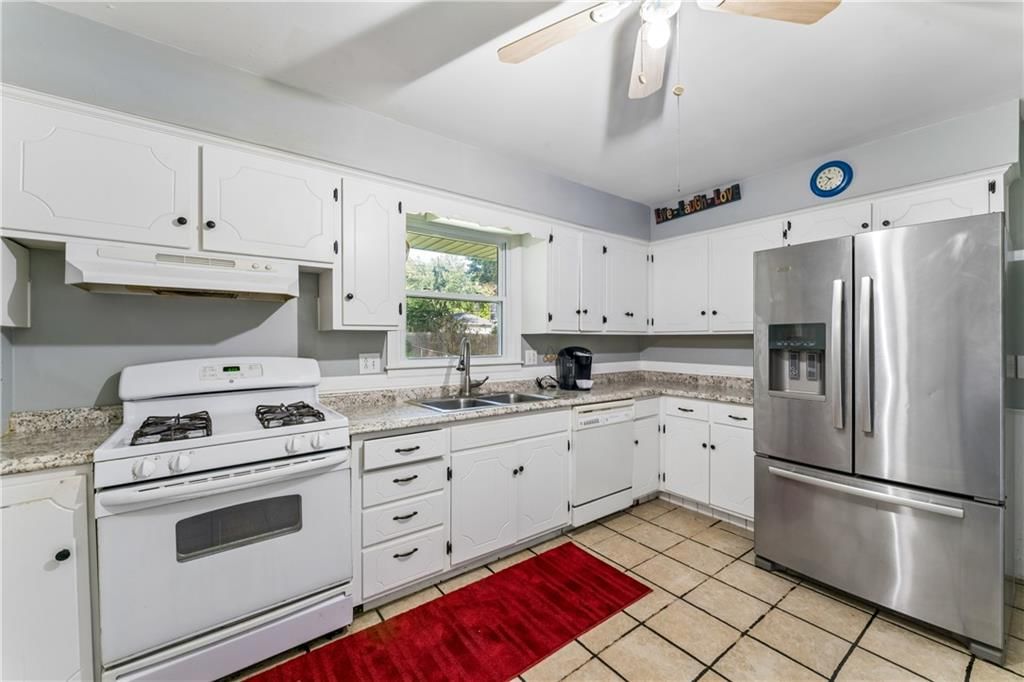 White kitchen, gas range and stainless steel appliances at 6808 Larsen Lane, Shawnee, KS 66203
