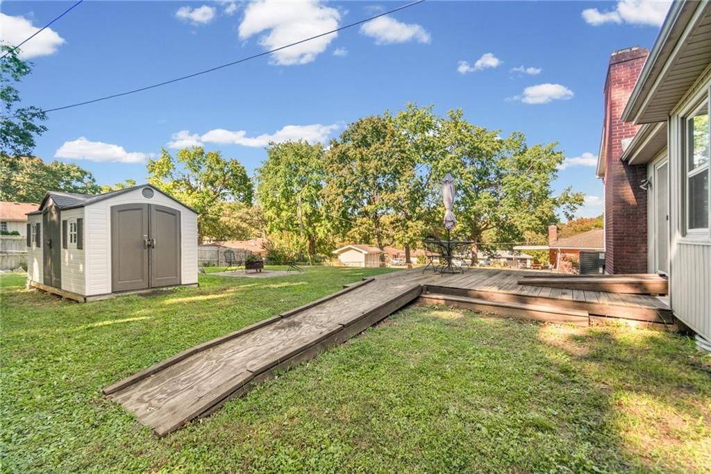 Big backyard, mature trees and chain-link fence at 7512 N Baltimore Avenue, Gladstone, MO 64118