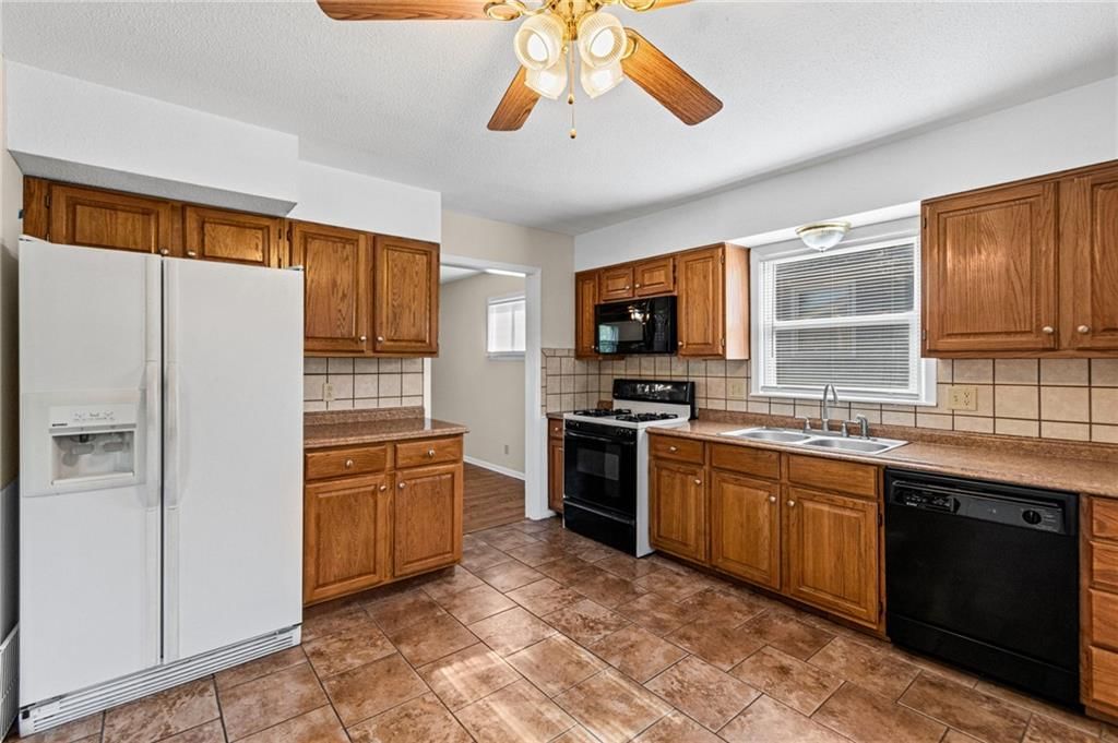 Kitchen backsplash, mixed-finish appliances and laminate countertops at 7512 N Baltimore Avenue, Gladstone, MO 64118