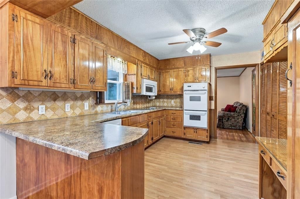 Wood kitchen cabinets, kitchen backsplash and beige or brown countertops at 8914 Park Street, Lenexa, KS 66215