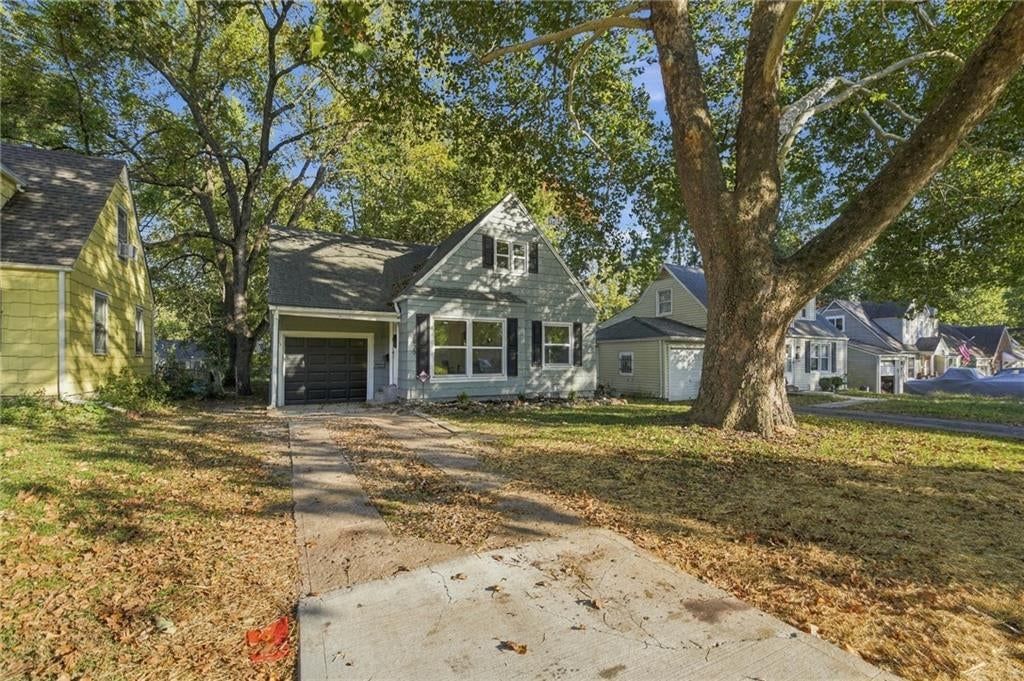 Ranch-style home, mature trees and concrete driveway at 7929 Madison Avenue, Kansas City, MO 64114