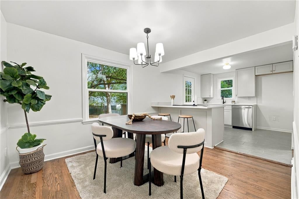 Kitchen open to the living area, white kitchen and statement lighting at 7929 Madison Avenue, Kansas City, MO 64114
