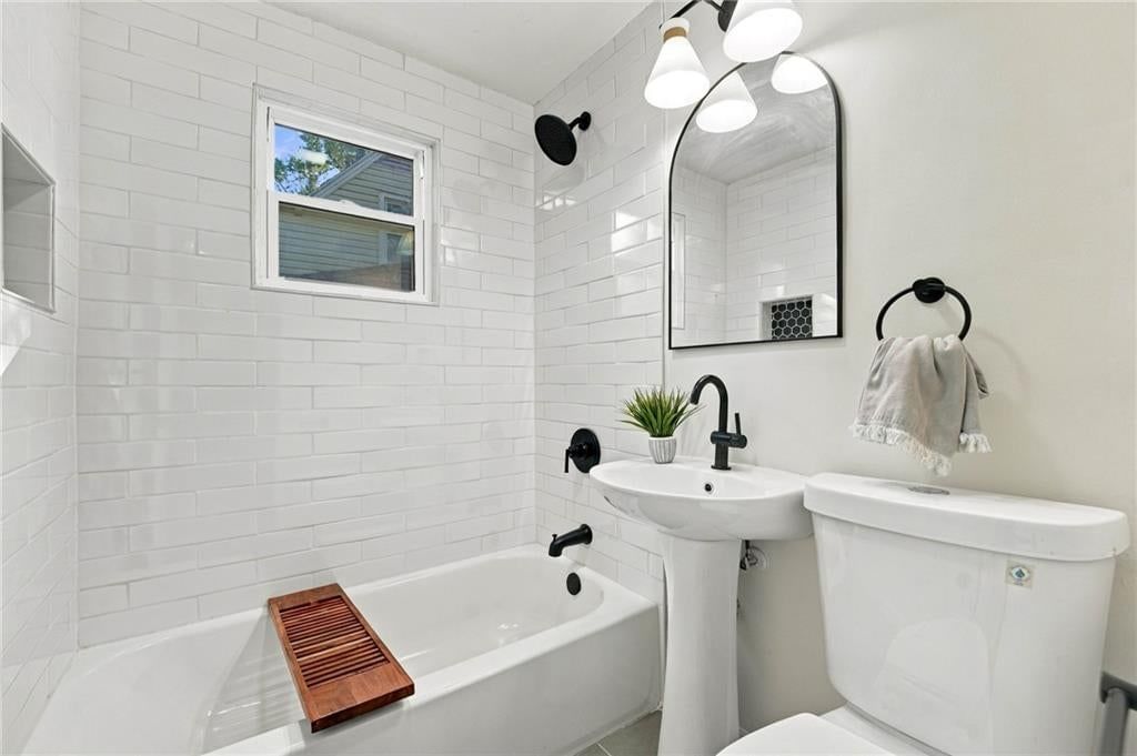 Tiled shower, renovated bathrooms and tub and shower combo at 7929 Madison Avenue, Kansas City, MO 64114