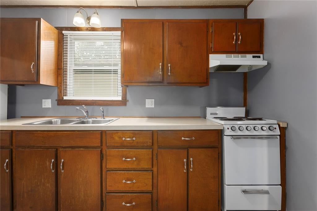 Gas range, wood kitchen cabinets and white appliances at 724 Seneca Street, Leavenworth, KS 66048