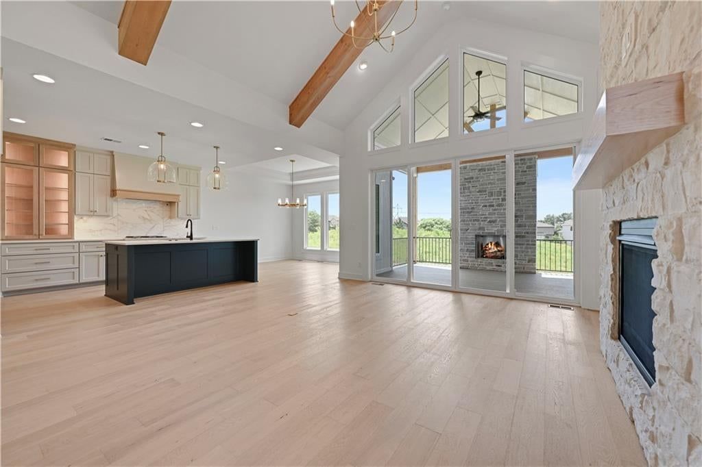 Floor-to-ceiling windows and stone fireplace at 15300 W 161st Court, Olathe, KS 66062