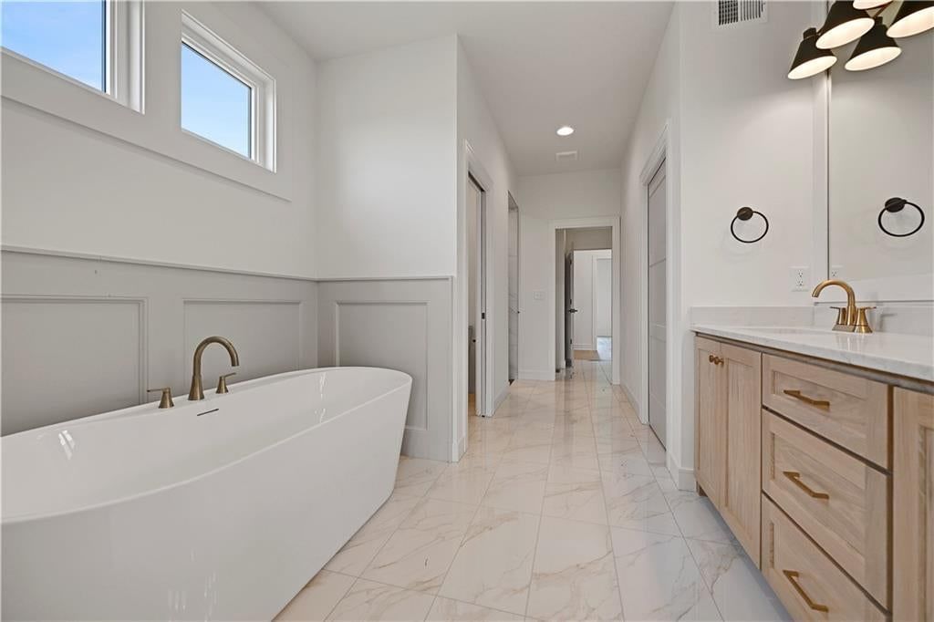 Tile floors, freestanding tub and double vanity at 15300 W 161st Court, Olathe, KS 66062