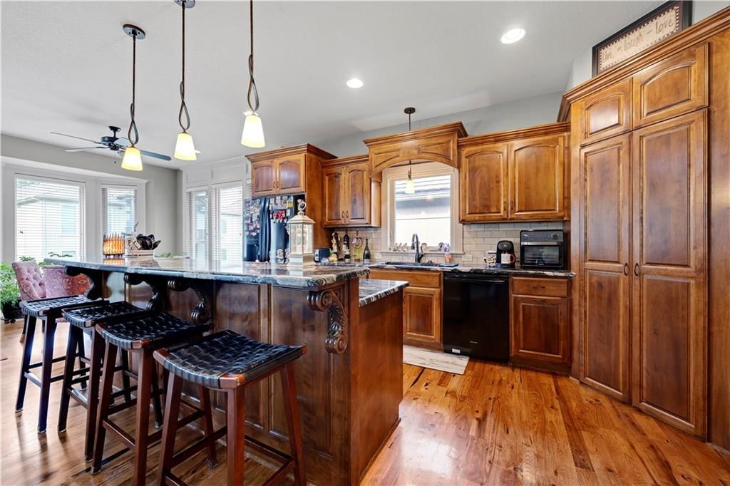 Kitchen island, stainless steel appliances and wood kitchen cabinets at 4323 NE Park Trails Court, Lee's Summit, MO 64064