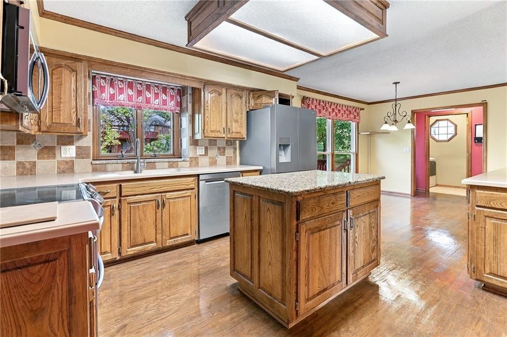 Kitchen island, stainless steel appliances and wood kitchen cabinets at 17612 E 48th Terrace Court S, Independence, MO 64055