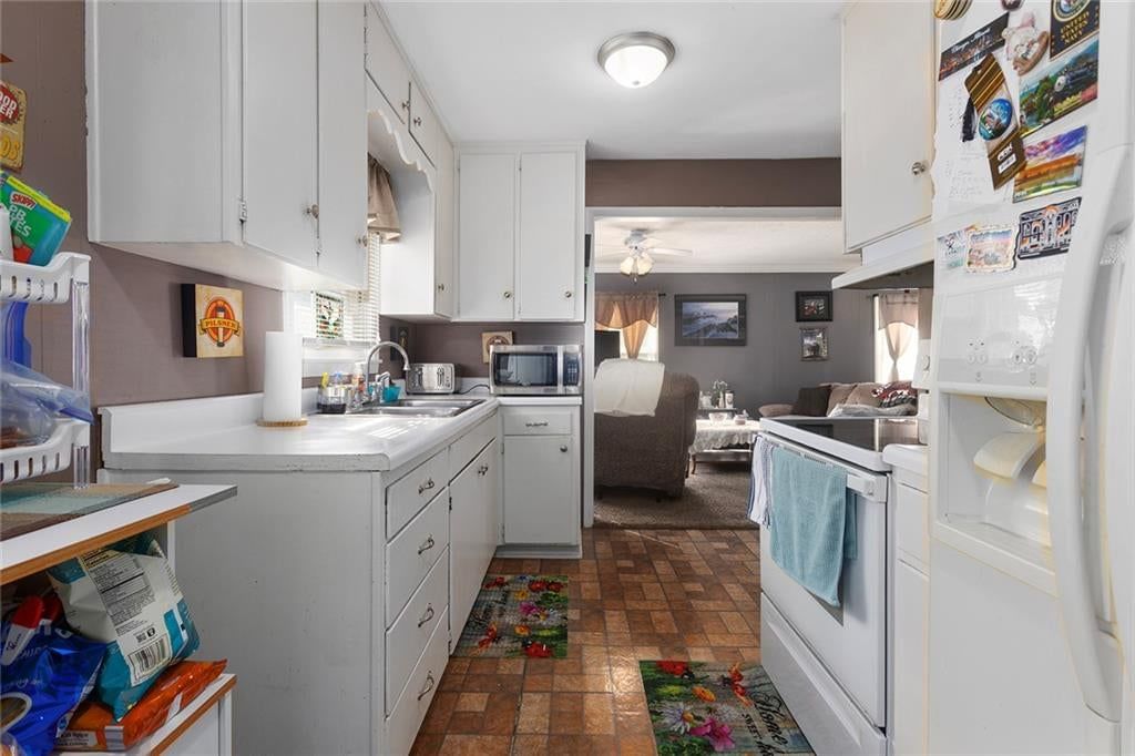 Kitchen open to the living area, white kitchen and tile floors at 2 NE 62 Terrace, Gladstone, MO 64118