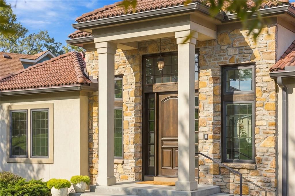 Covered front porch and mediterranean style at 7810 NW Scenic Drive, Weatherby Lake, MO 64152