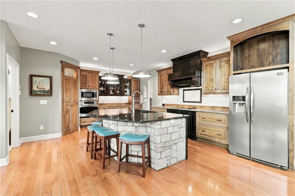 Kitchen island, gas range and stainless steel appliances at 7810 NW Scenic Drive, Weatherby Lake, MO 64152
