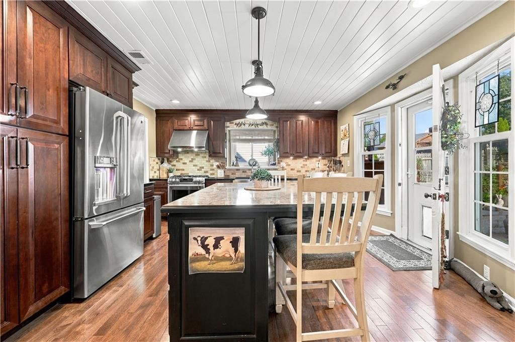 Kitchen open to the living area, kitchen island and quartz counters at 12908 E 58th Street, Kansas City, MO 64133