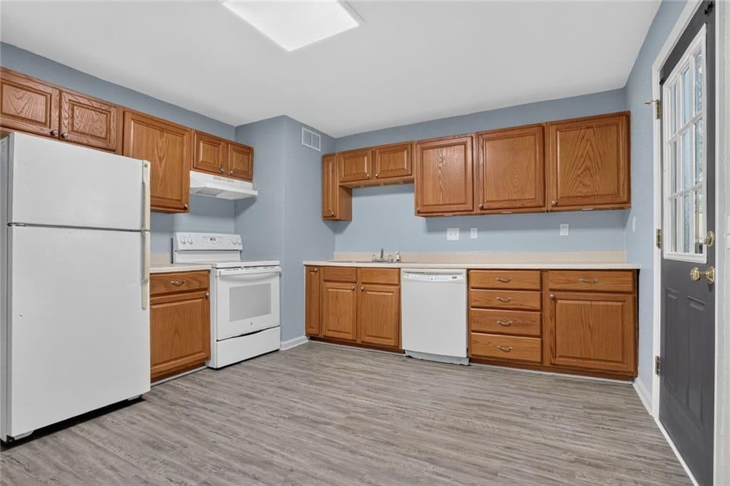 Wood kitchen cabinets, white appliances and electric range at 6202 E 147th Terrace, Grandview, MO 64030