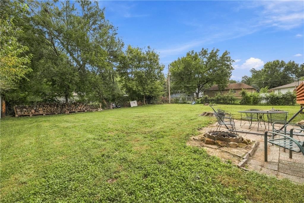Big backyard, mature trees and fire pit at 8427 Jame A Reed Road, Raytown, MO 64138