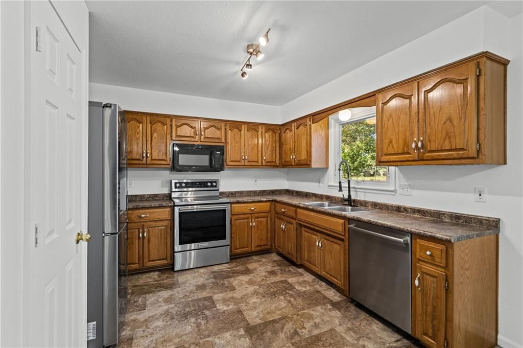 Granite counters, electric range and kitchen backsplash at 29408 Vickie Drive, Excelsior Springs, MO 64024