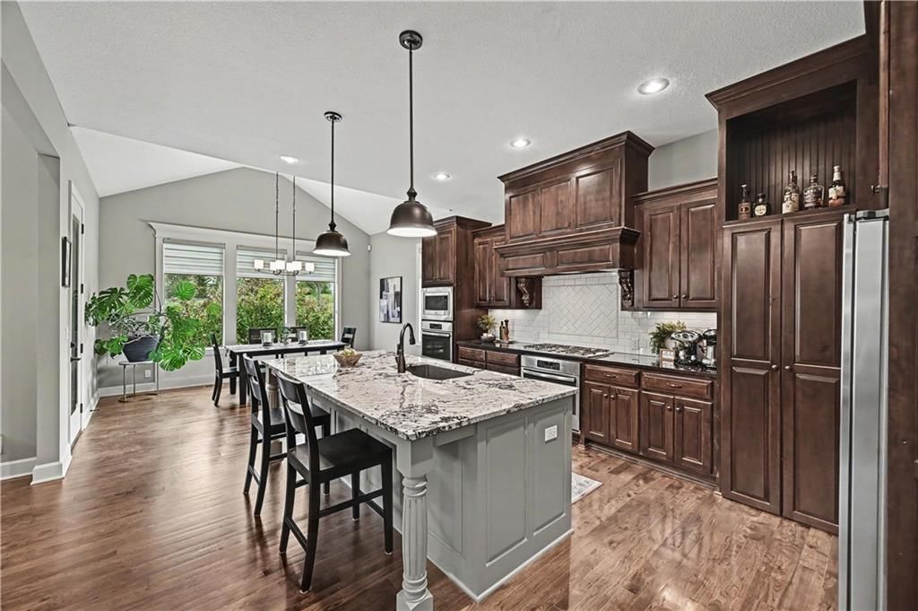 Kitchen island, granite counters and gas range at 10812 W 153rd Street, Overland Park, KS 66221