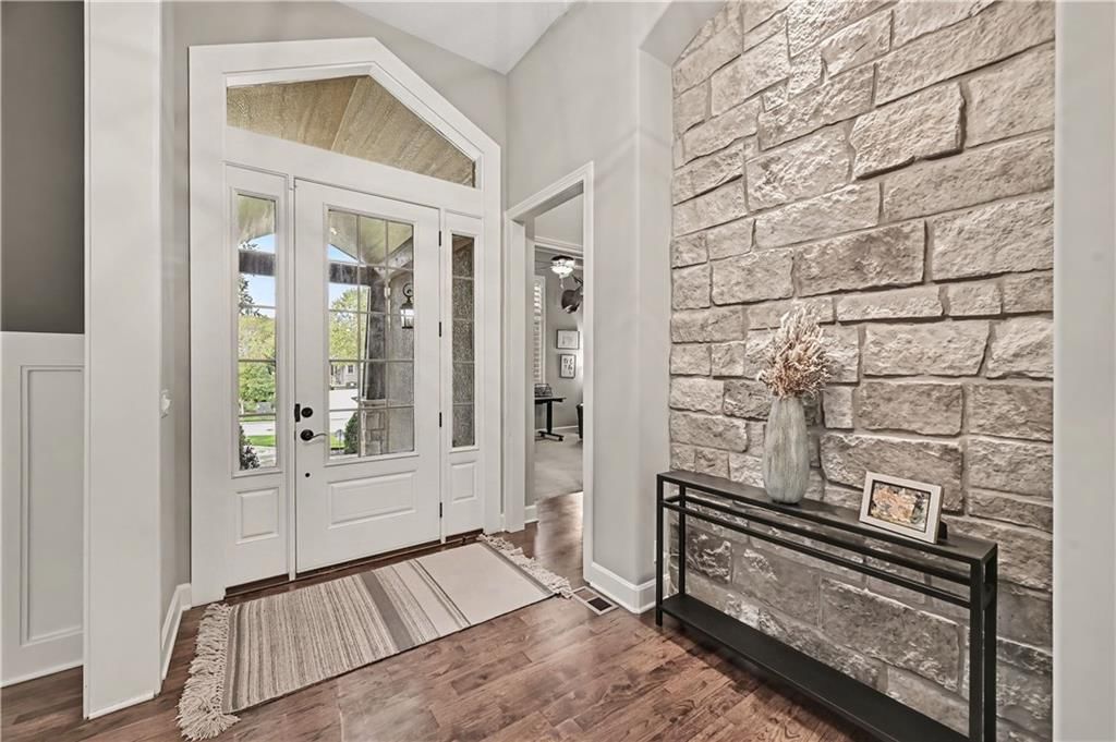 Hardwood floors, shiplap / paneling and black hardware at 10812 W 153rd Street, Overland Park, KS 66221