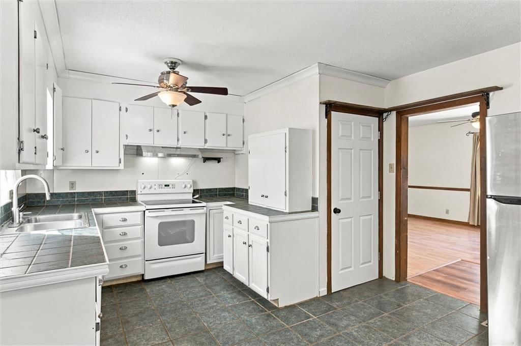 Open floor plan, white kitchen and electric range at 1504 9th Avenue, Leavenworth, KS 66048
