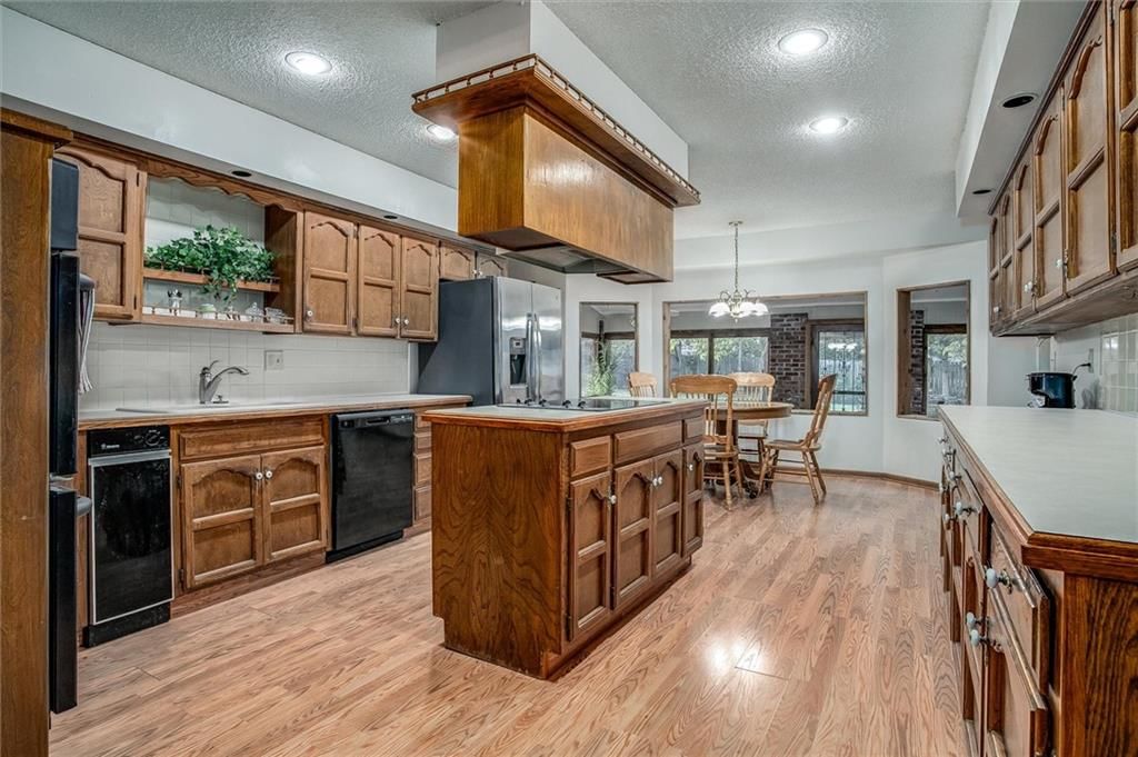 Kitchen island, granite counters and wood kitchen cabinets at 9007 E 68th Street, Raytown, MO 64133