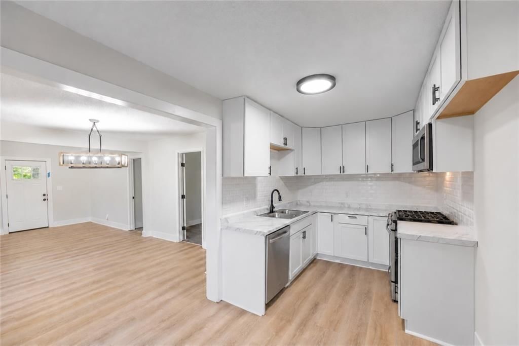 White kitchen, gas range and shaker cabinets at 3426 Cypress Avenue, Kansas City, MO 64130