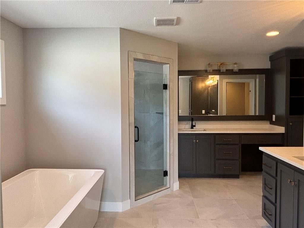 Tile floors, walk-in shower and freestanding tub at 1820 SW Arbormist Drive, Lee's Summit, MO 64082