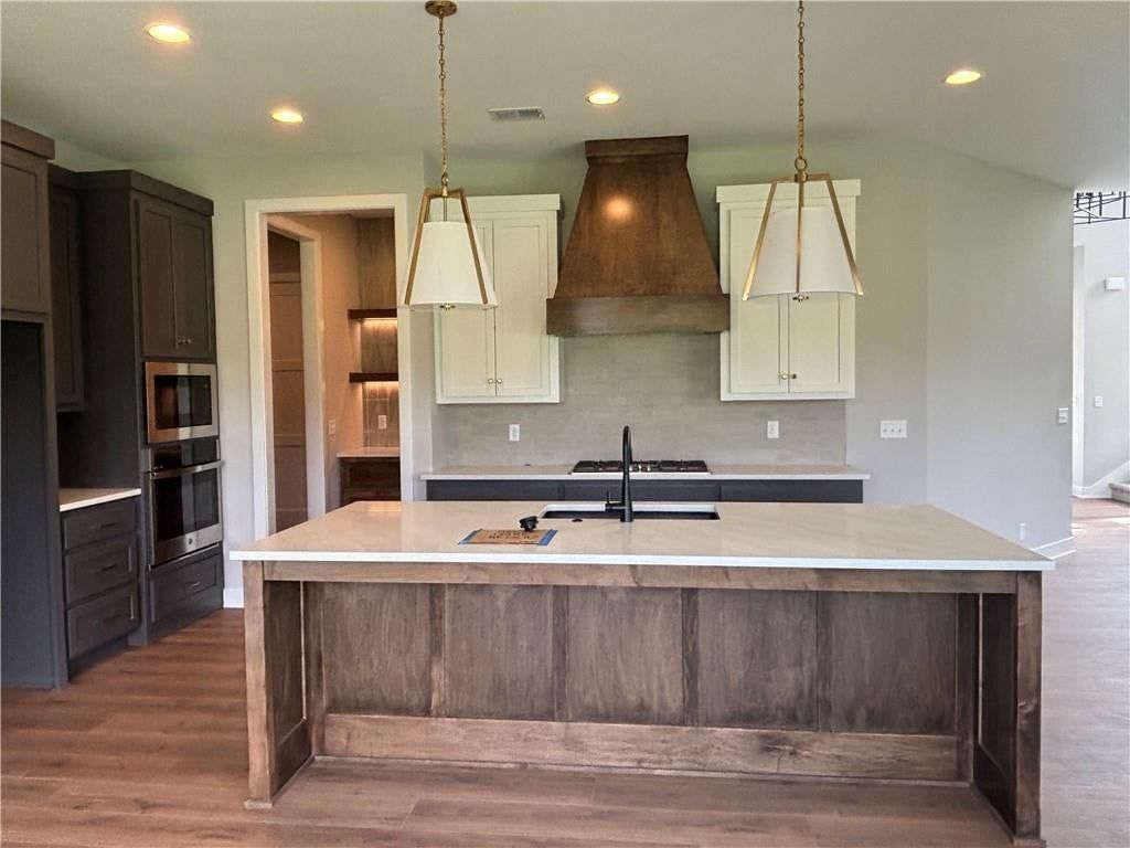 Open floor plan, kitchen island and statement lighting at 1820 SW Arbormist Drive, Lee's Summit, MO 64082