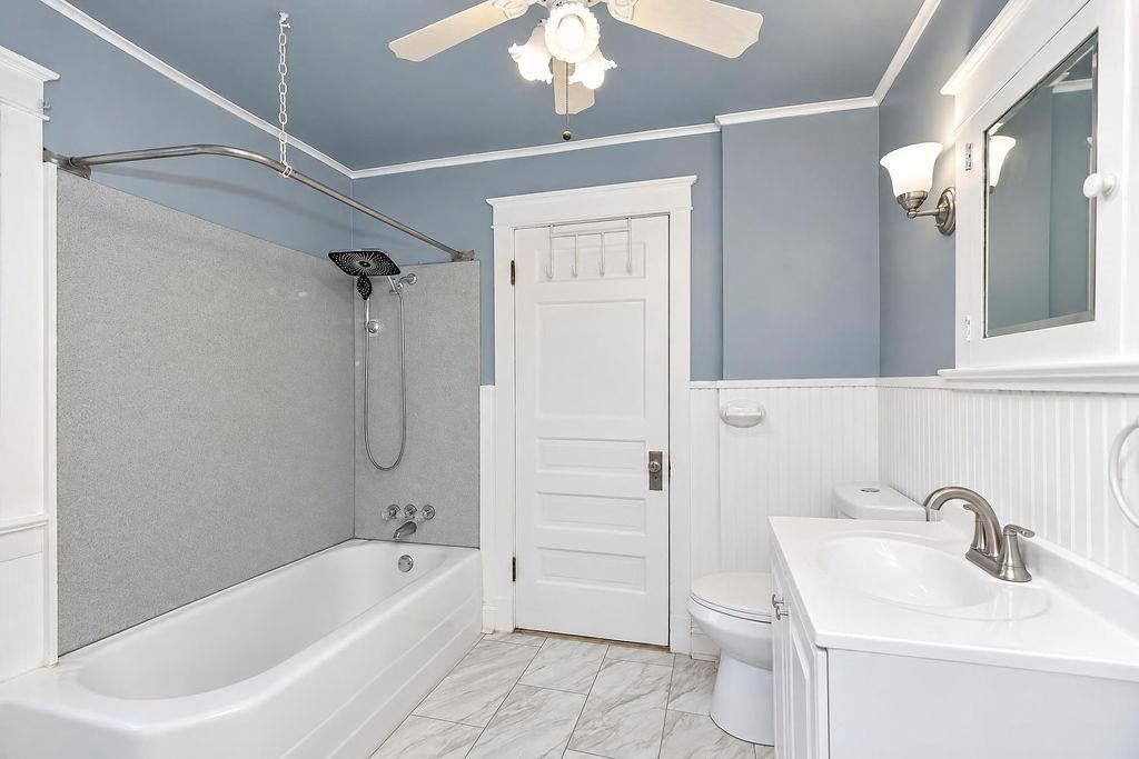 Wainscoting or board and batten, tiled shower and double vanity at 4217 Holmes Street, Kansas City, MO 64110