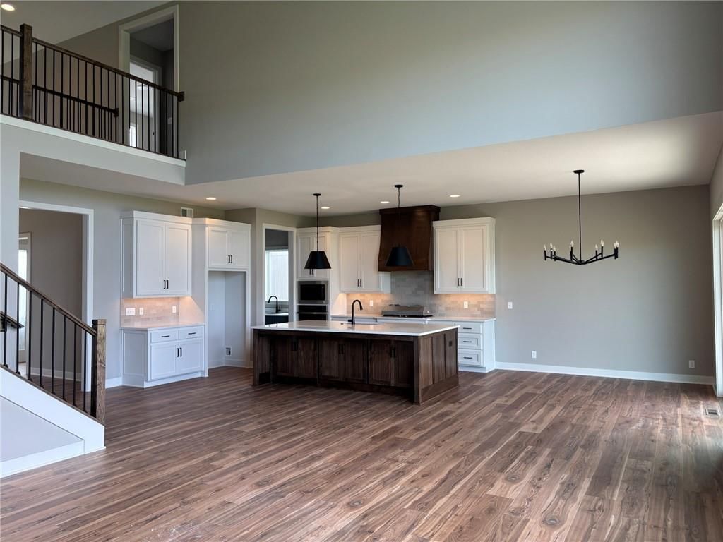 Kitchen island, white kitchen cabinets and quartz counters at 1816 SW Arbormist Drive, Lee's Summit, MO 64082