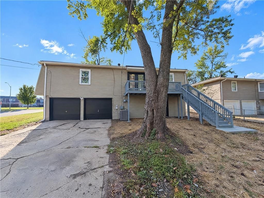Attached garage, gray exterior and concrete driveway at 1400 NW 65th Terrace, Kansas City, MO 64118